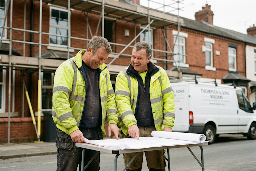 Tradespeople reviewing plans outside a property